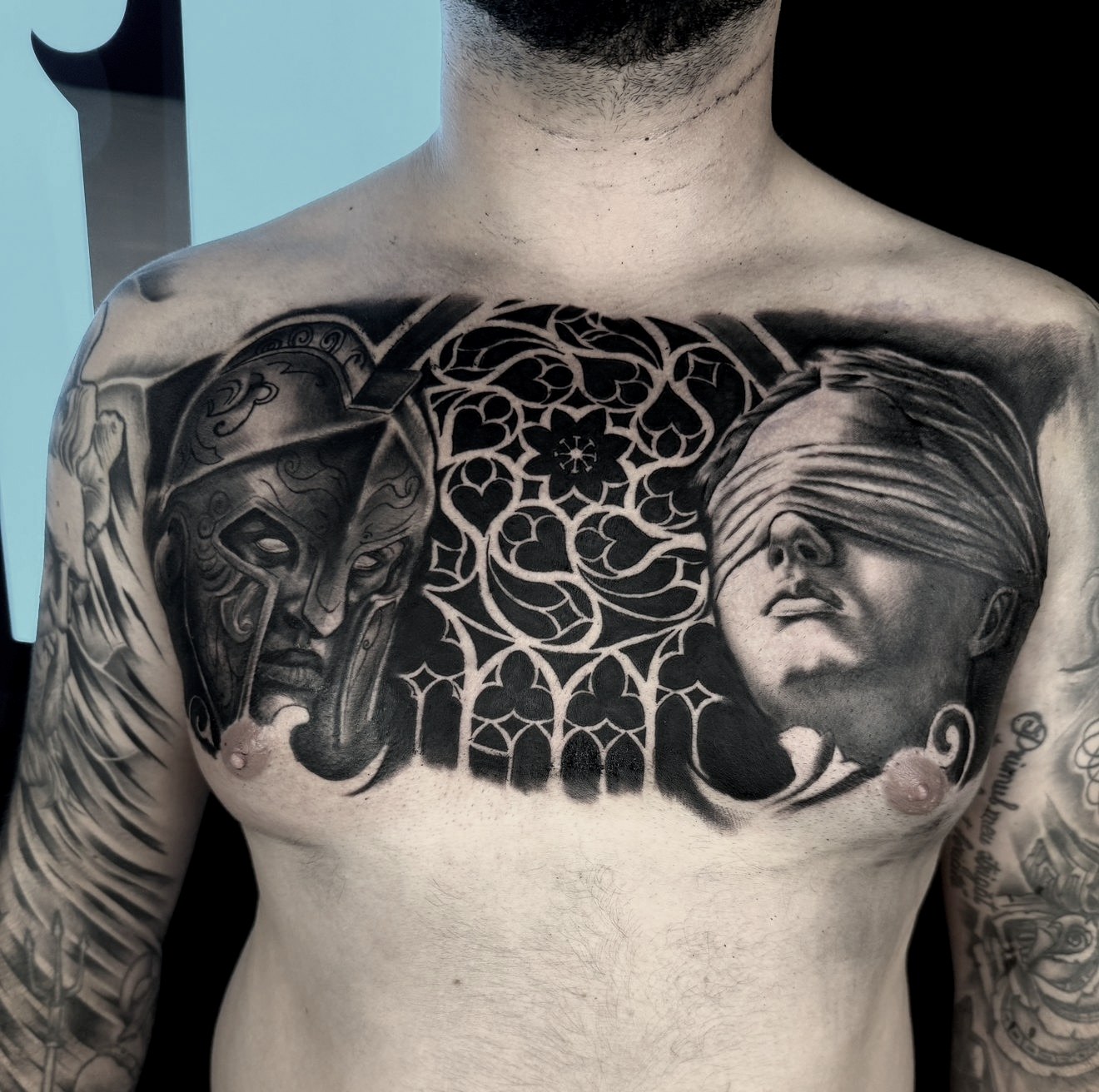 Tatuaj pe piept cu războinic cu coif, chip de statuie legată la ochi și ornament de vitraliu gotic, black and grey, Shonti Alex, Ace Tattoo București