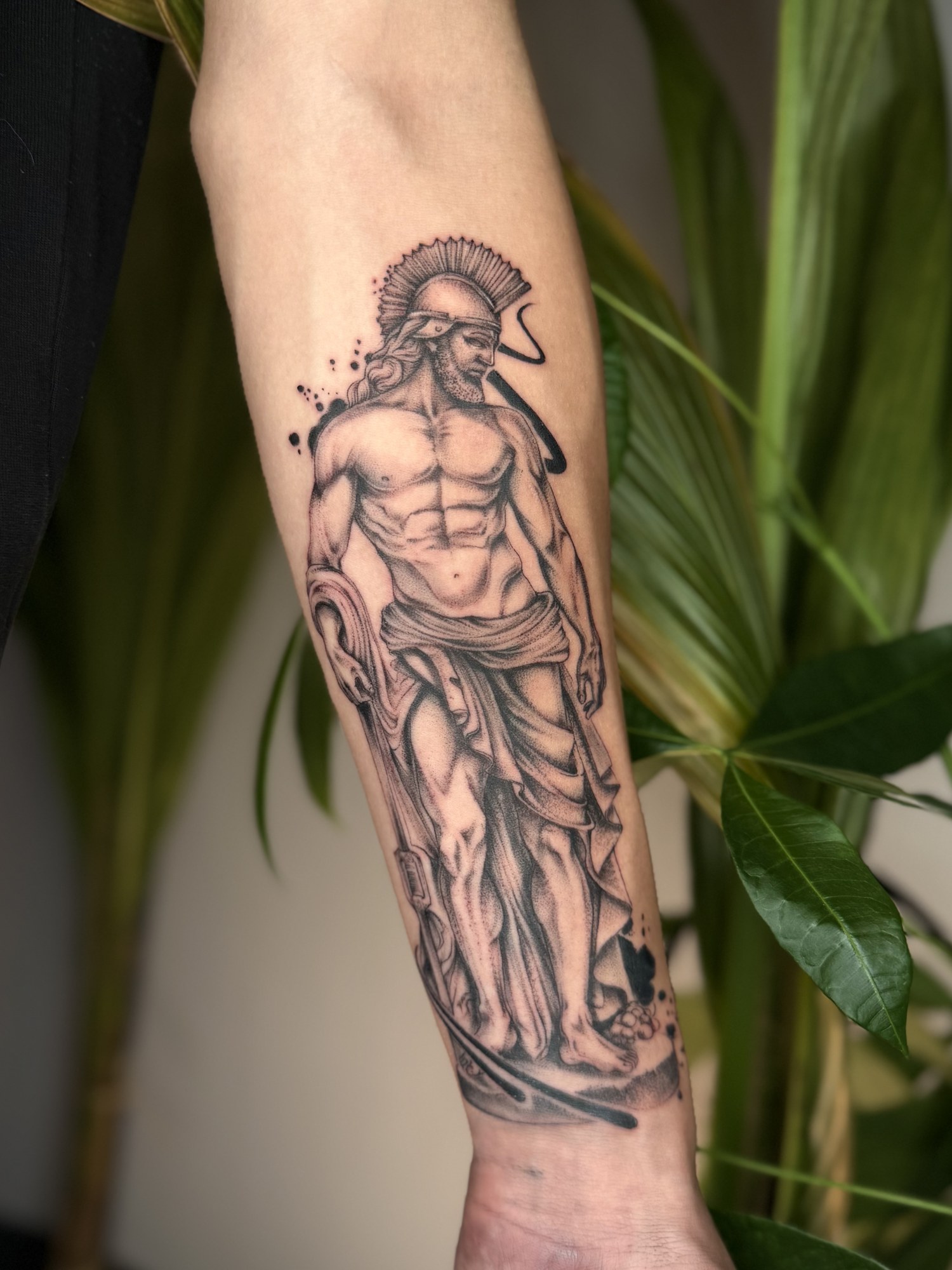 Tatuaj statuie de războinic cu accente roșii pe antebraț, black and grey, Vlady, guest artist Ace Tattoo București
