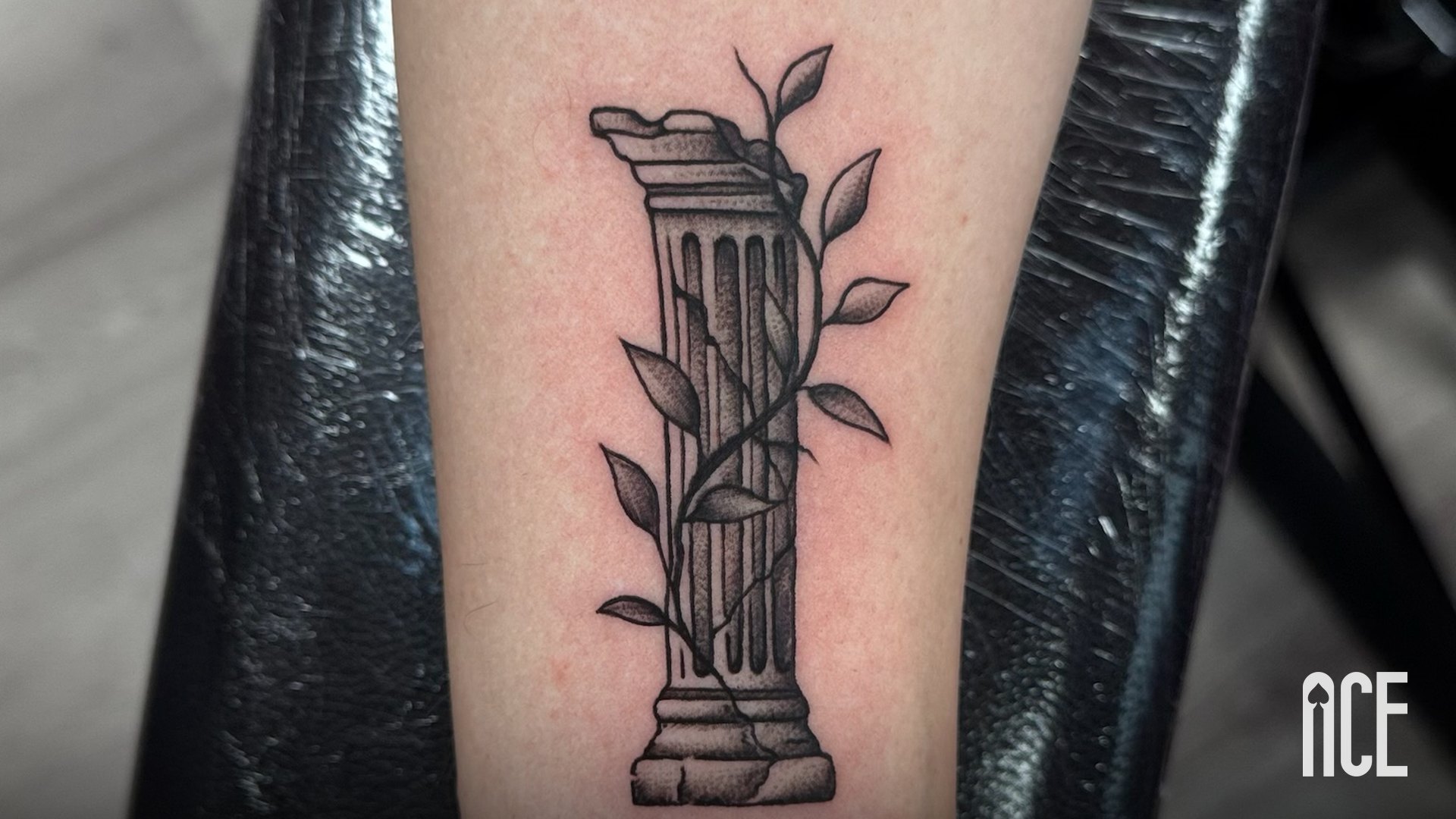 Tatuaj black and grey cu o coloană antică și iederă pe antebraț, realizat la Ace Tattoo în Sector 1, București