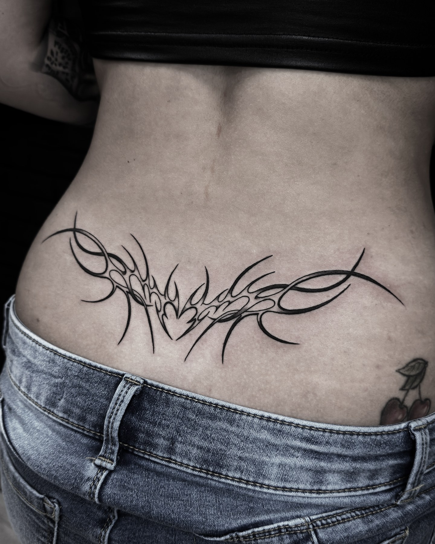 Ornament tribal pe zona lombară, tatuaj fine line de Vlad Shulea la Ace Tattoo București