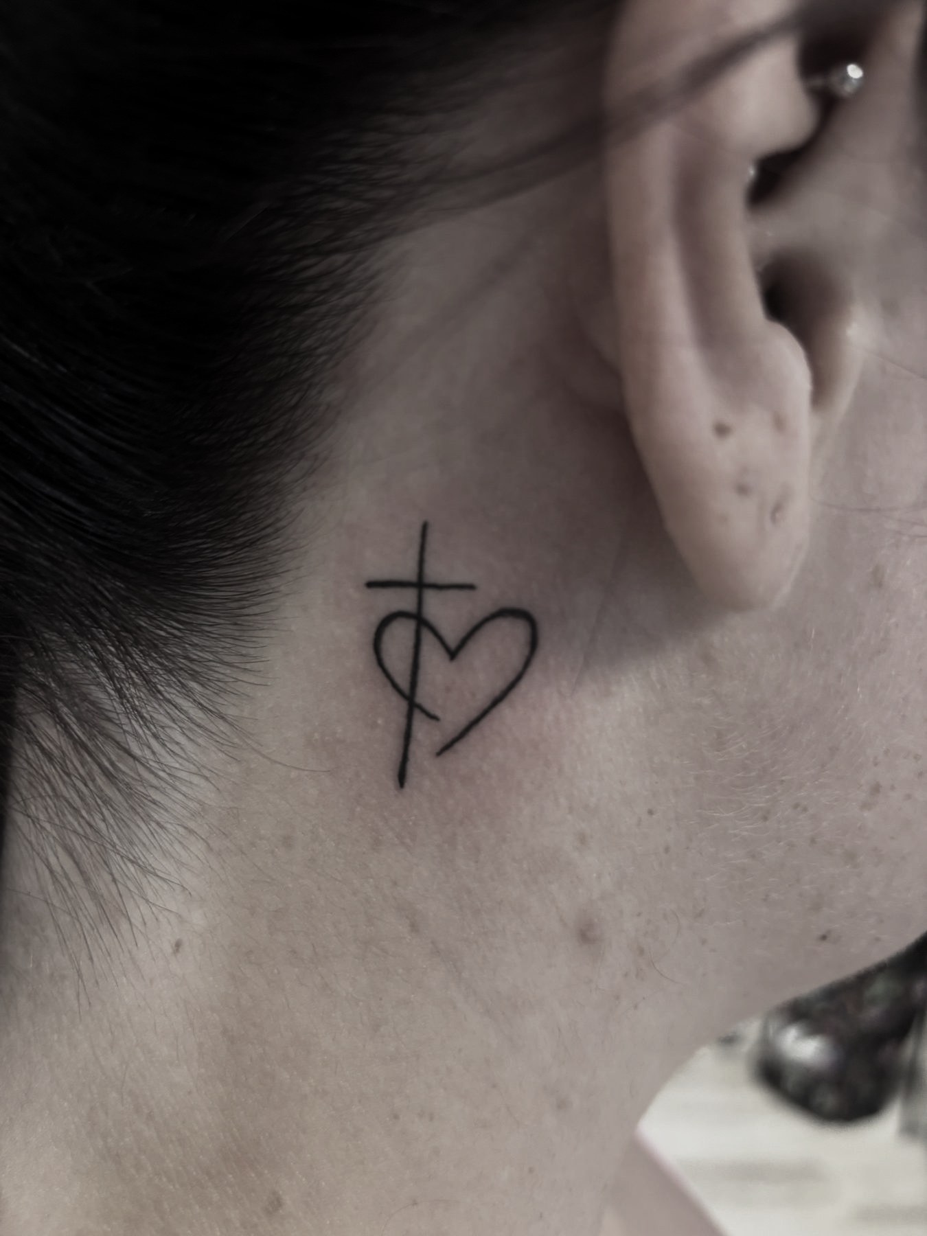 Tatuaj mic cu cruce și inimă în spatele urechii, Vlad Shulea, Ace Tattoo București