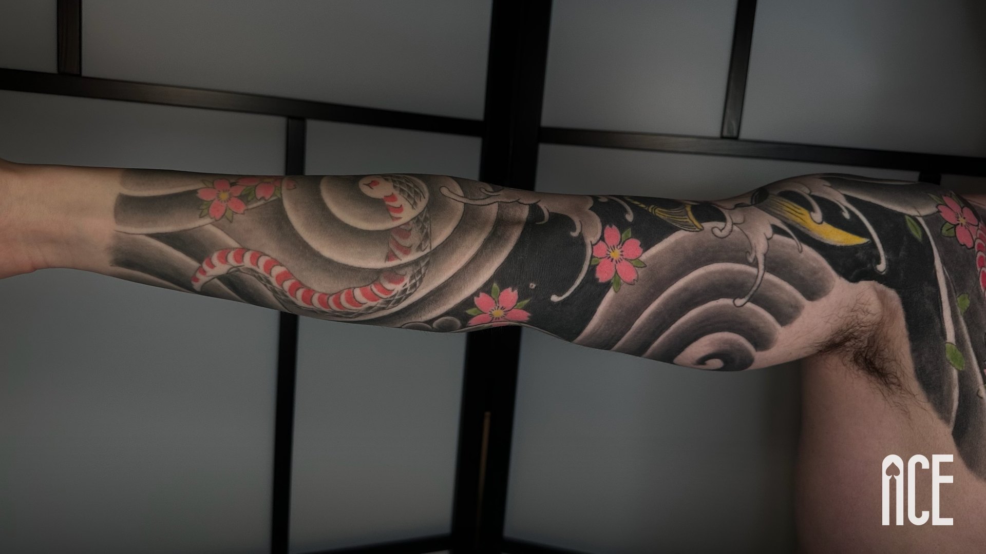 Sleeve japonez vindecat cu șarpe, valuri și flori de cireș pe braț, lucrare Ace Tattoo în Sector 1, București